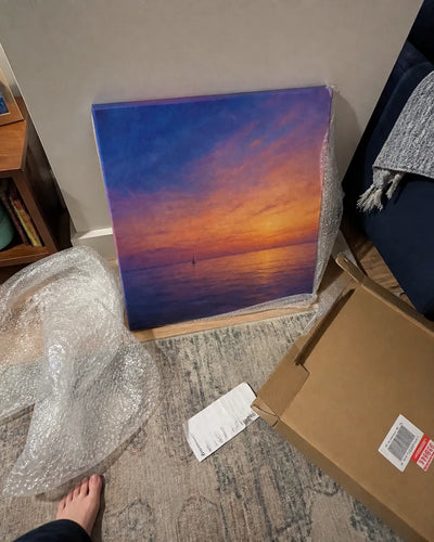 Customer photo of the canvas just unpacked, still leaning against the wall with the shipping box